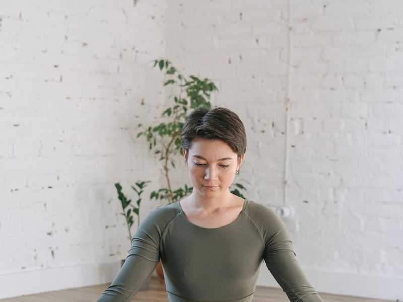Minimalist yoga studio with green neon lighting on walls.