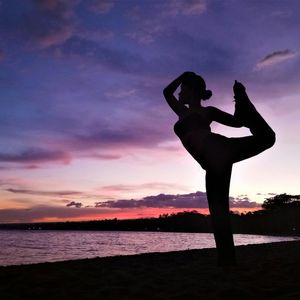Silhouette of person in a tree pose yoga position.